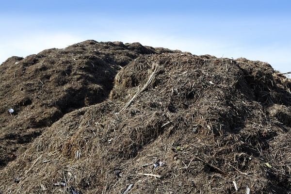 large compost pile against a blue sky