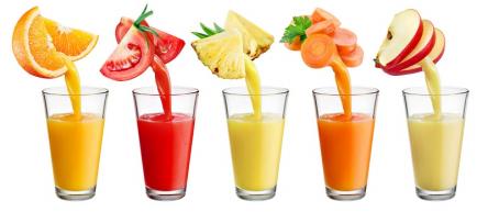 five different fruits with their juices flowing into glass cups