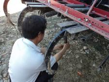 Hmong farmer works on farm equipment