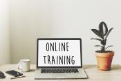 a computer with the words &quot;online training&quot; sitting next to a plant
